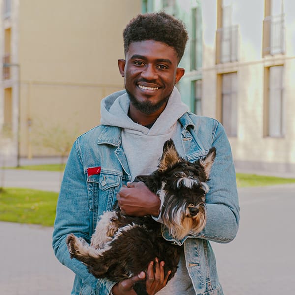 Gentleman Holding Older Dog Outside On Street
